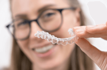 Woman holding Invisalign aligners up to the camera