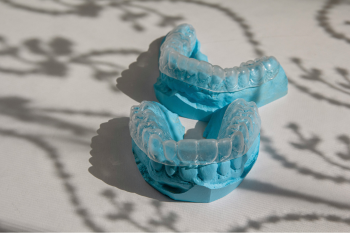Invisalign clear braces sitting on top of a blue mould